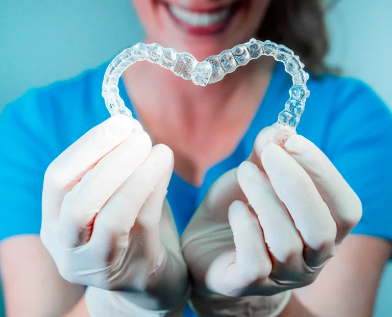 Dental professional holding a clear aligner